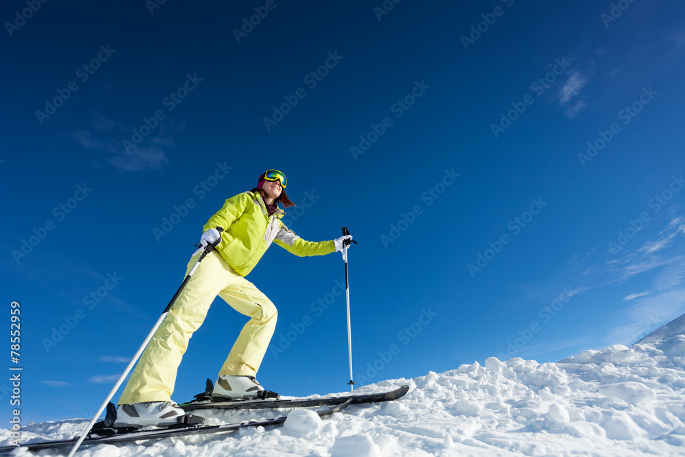戴口罩的年轻女子拿着滑雪杆滑雪