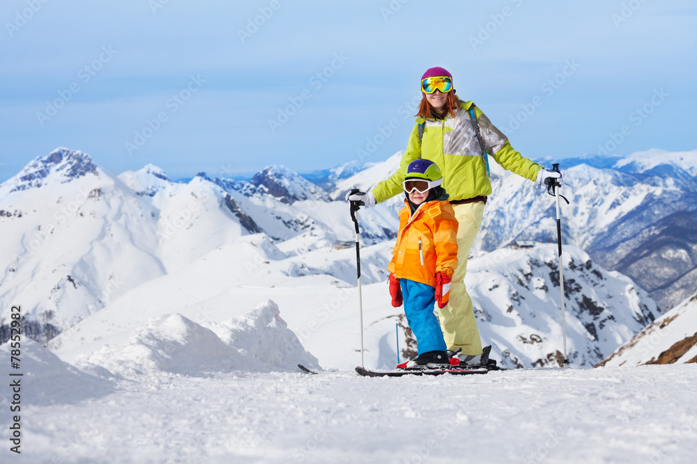 母亲带着男孩在山上滑雪