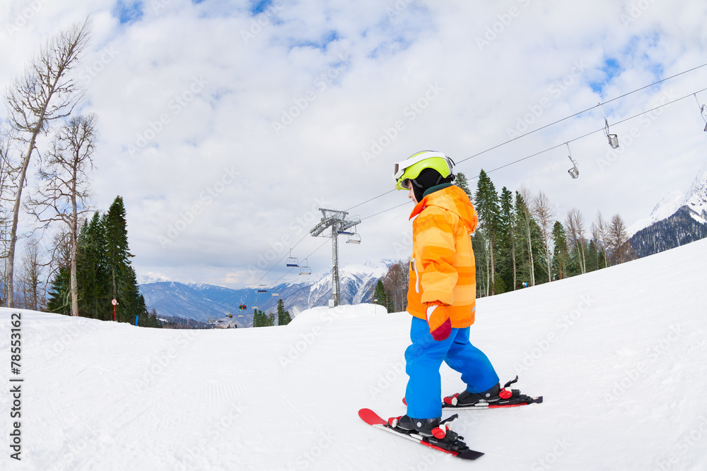 后面的男孩戴着滑雪面罩和头盔滑雪