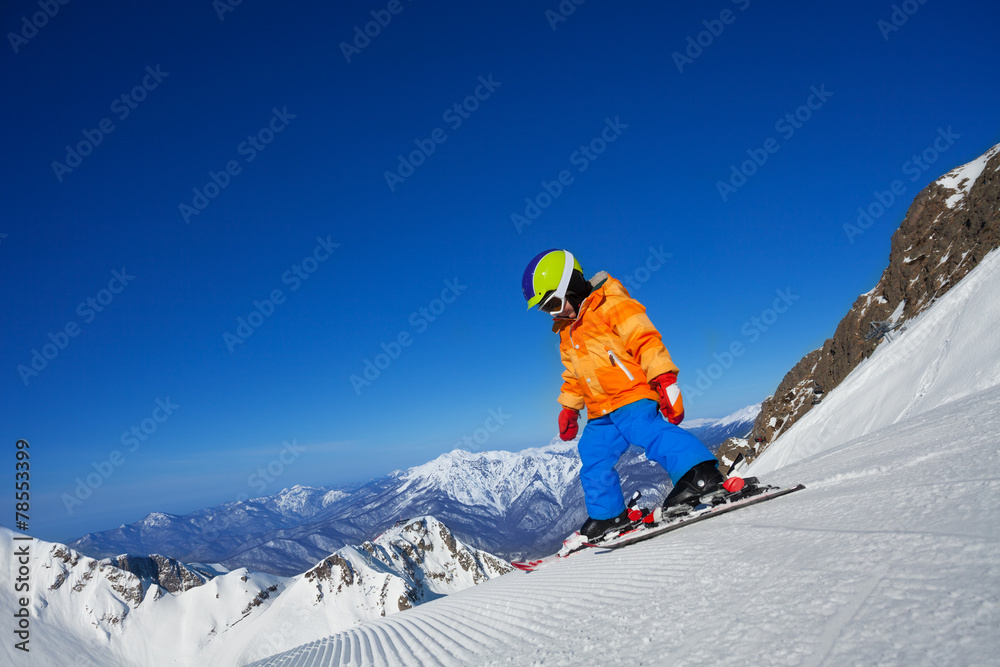 勇敢的小男孩独自在山坡上滑雪