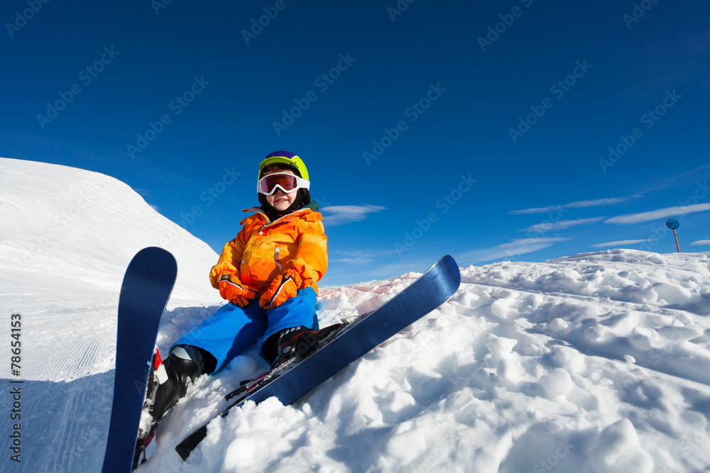雪地上戴着滑雪面罩和头盔的微笑男孩