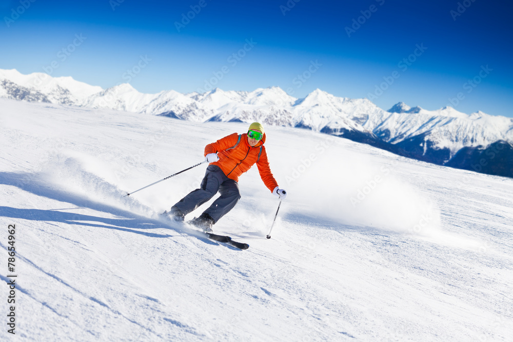 戴口罩的滑雪运动员在斜坡上滑雪时快速滑行