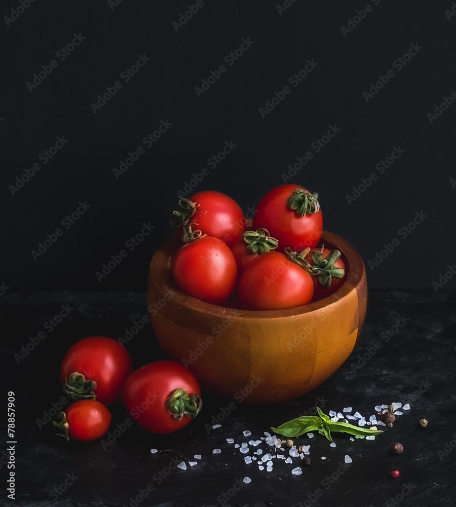 用罗勒叶将成熟的樱桃番茄放在木碗中