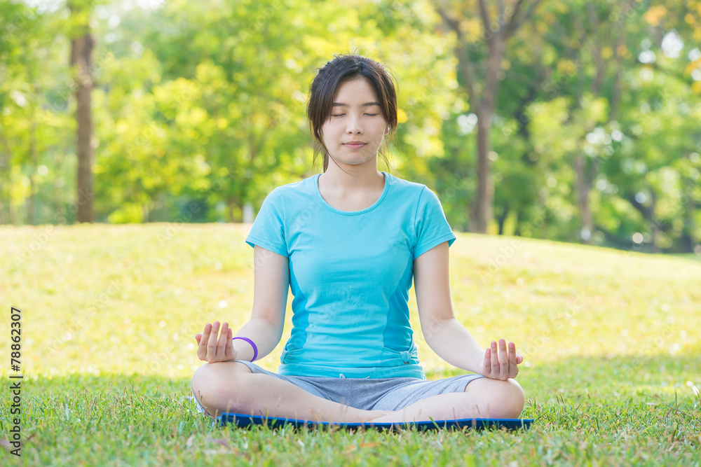 亚洲女子在公园练习瑜伽，保持呼吸姿势