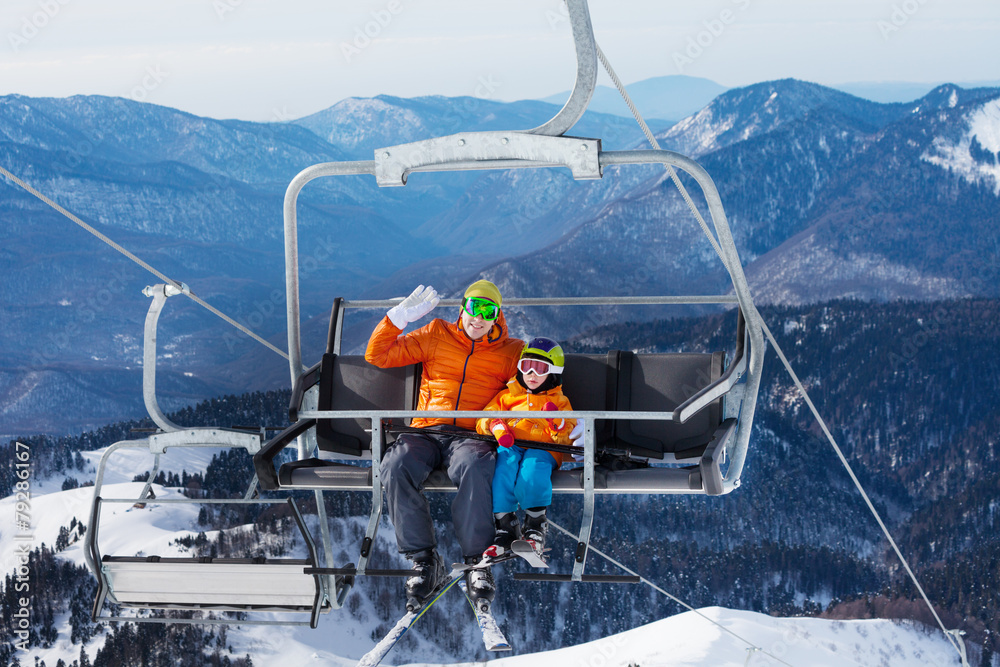 索道椅上带儿童升降机的男子滑雪者