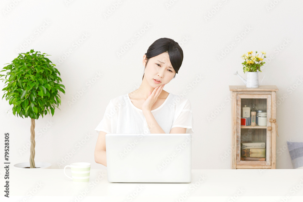 パソコンの前で困る女性