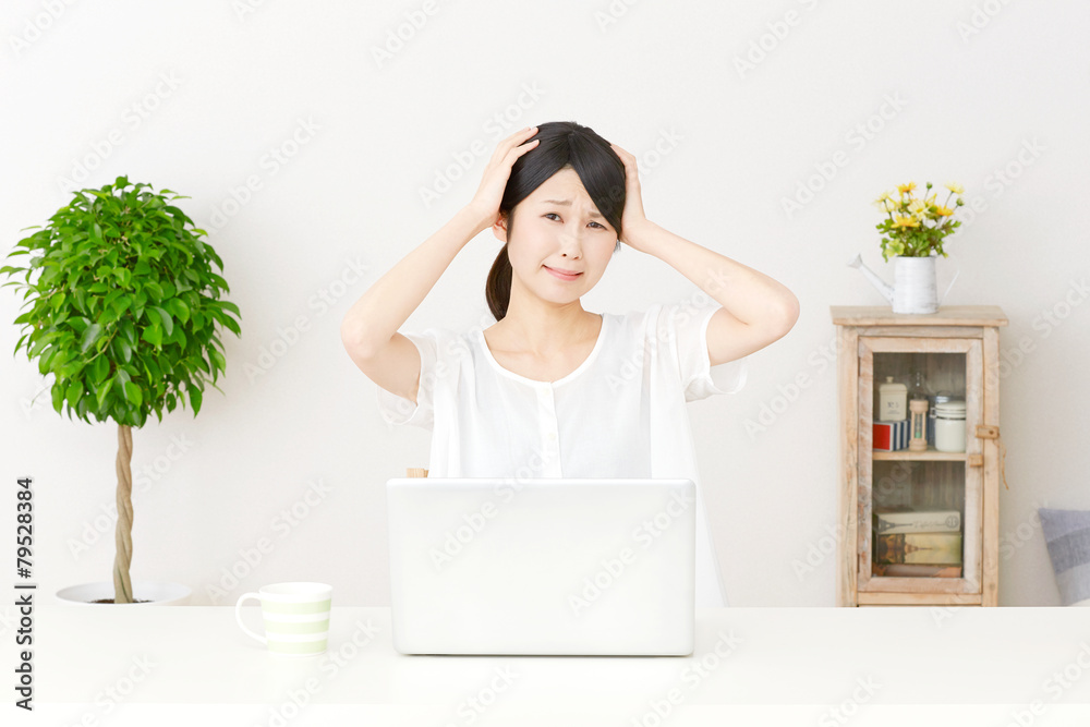 パソコンの前で頭を抱える女性