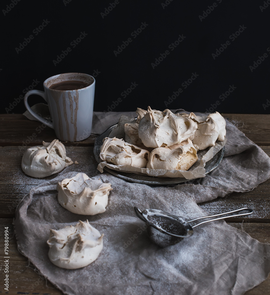 Meringues and mug of hot chocolate on a rustic wooden table
