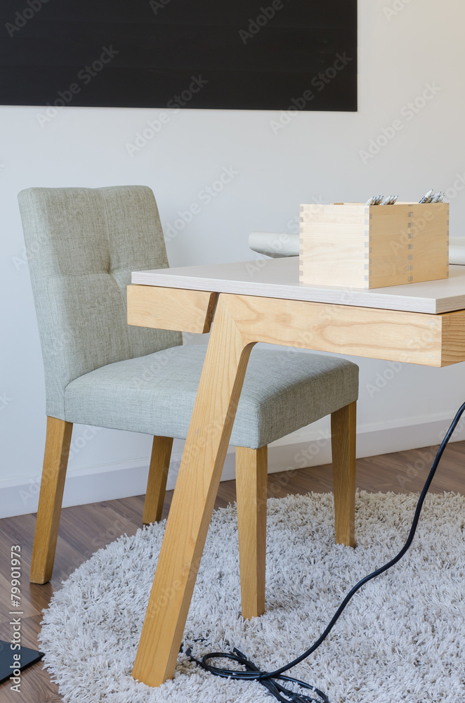 现代木制办公桌，地毯上有椅子