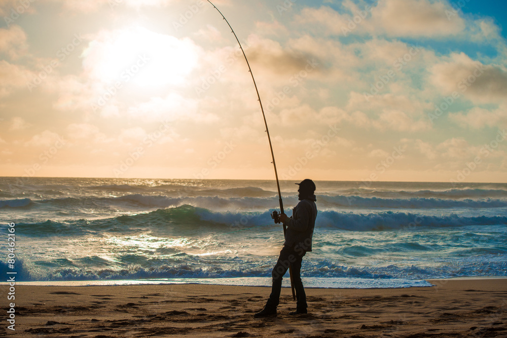 Man fishing on Beach at Sunset