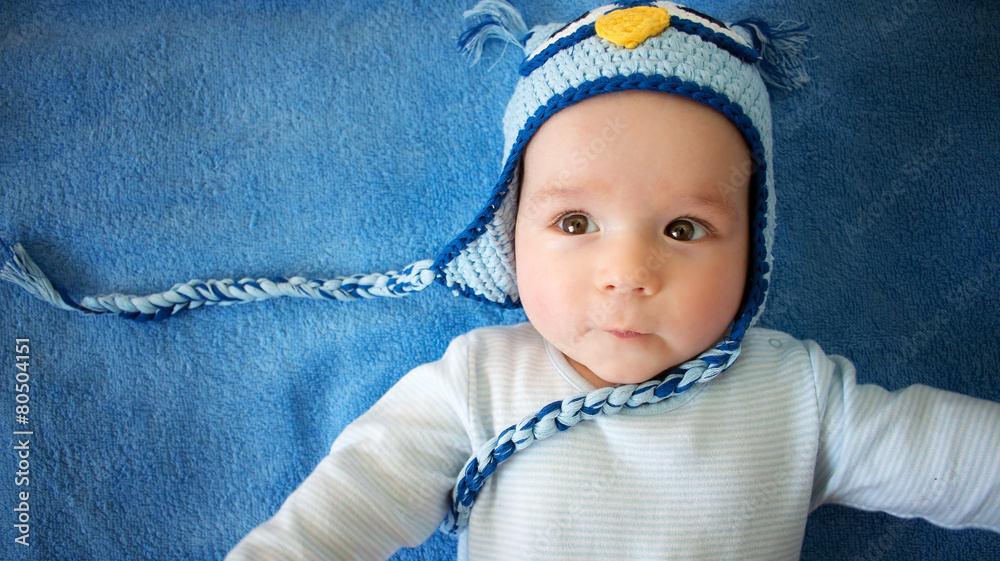 蓝色背景戴猫头鹰帽的小婴儿