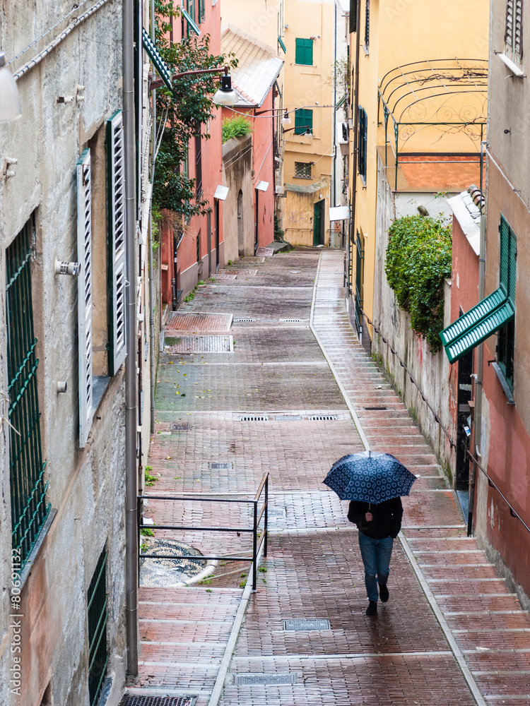 一名男子在热那亚小巷的雨中行走