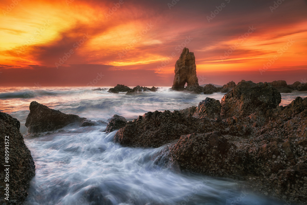 日落时海浪冲击岩石