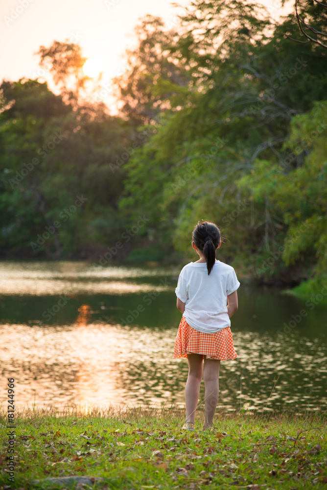可爱的亚洲小女孩看着美丽的湖泊
