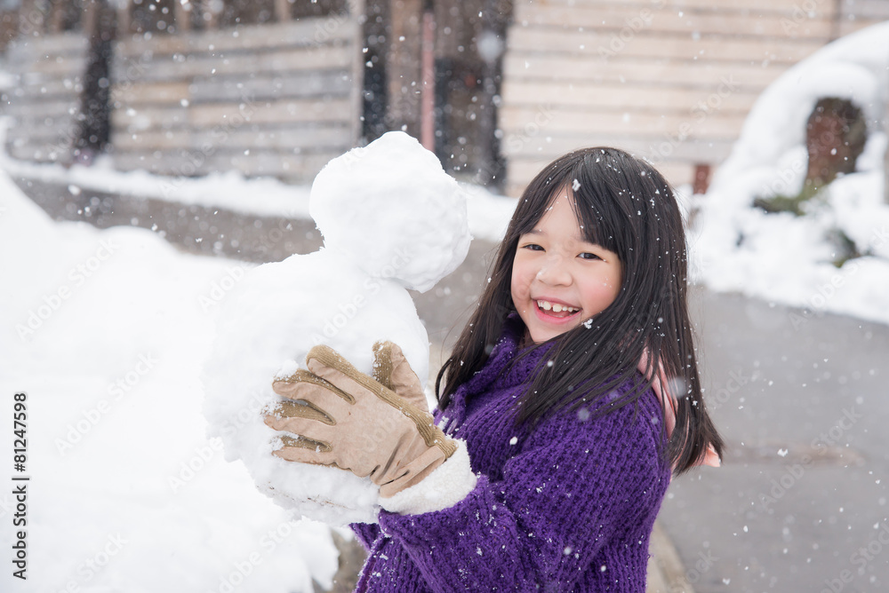 可爱的亚洲女孩在雪地里微笑