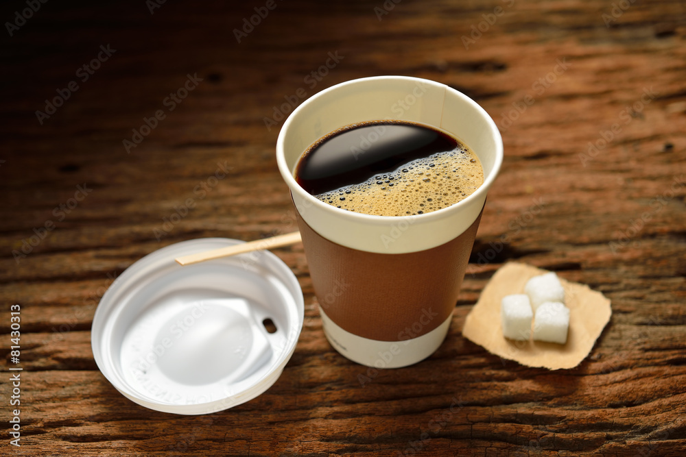 木制背景的纸杯咖啡和方糖