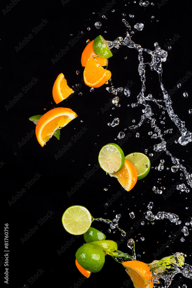 Limes and Orange with water splash on black（柠檬和橙子，黑色上有水滴）