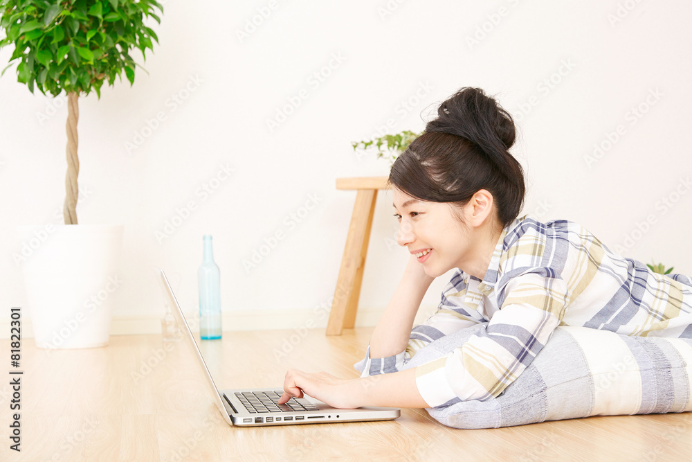 部屋でパソコンを使う女性