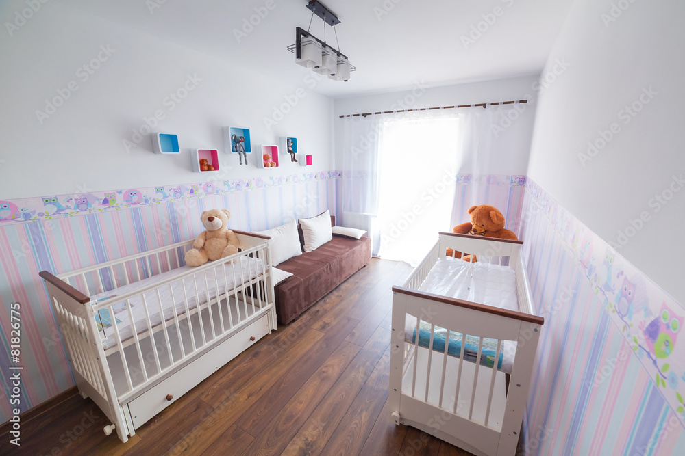 明亮的婴儿房，配有柔和的壁纸和白色摇篮