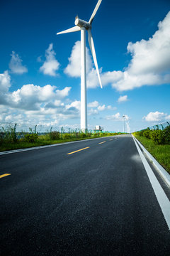 空旷的道路上的风力涡轮机映衬着天空