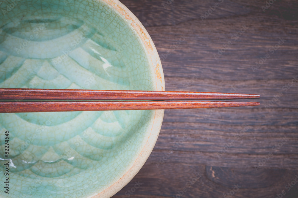 木桌背景上的筷子和青瓷绿色陶瓷