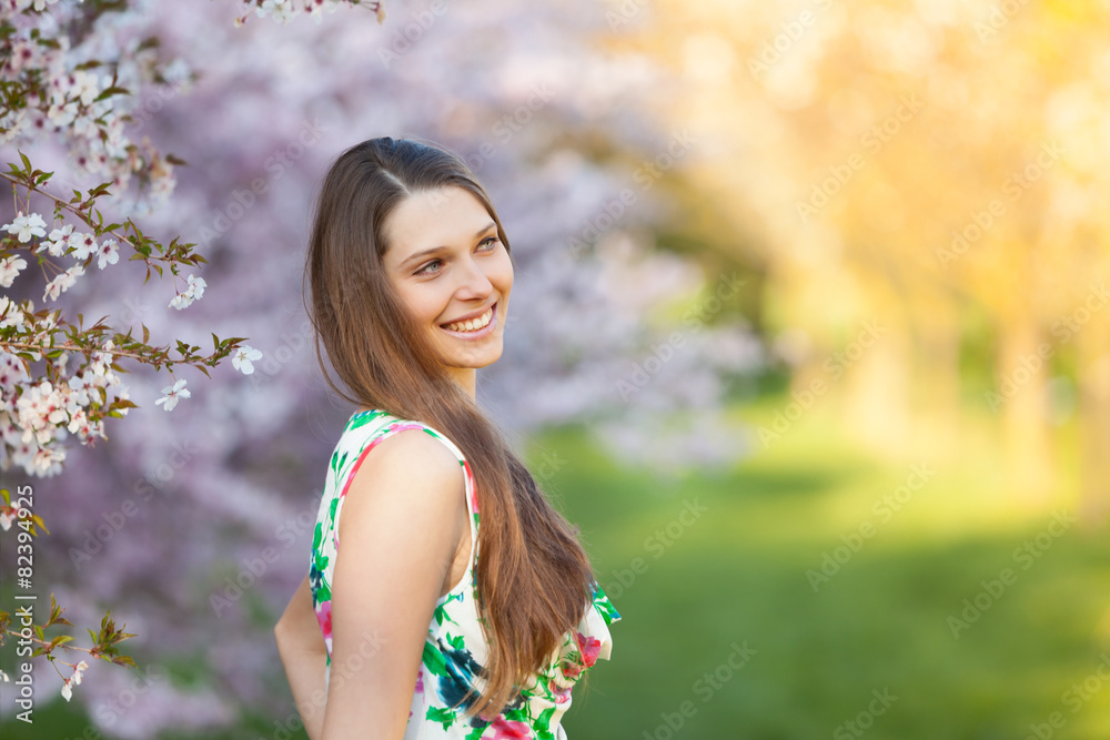 Beautiful  brunette woman in blooming orchard