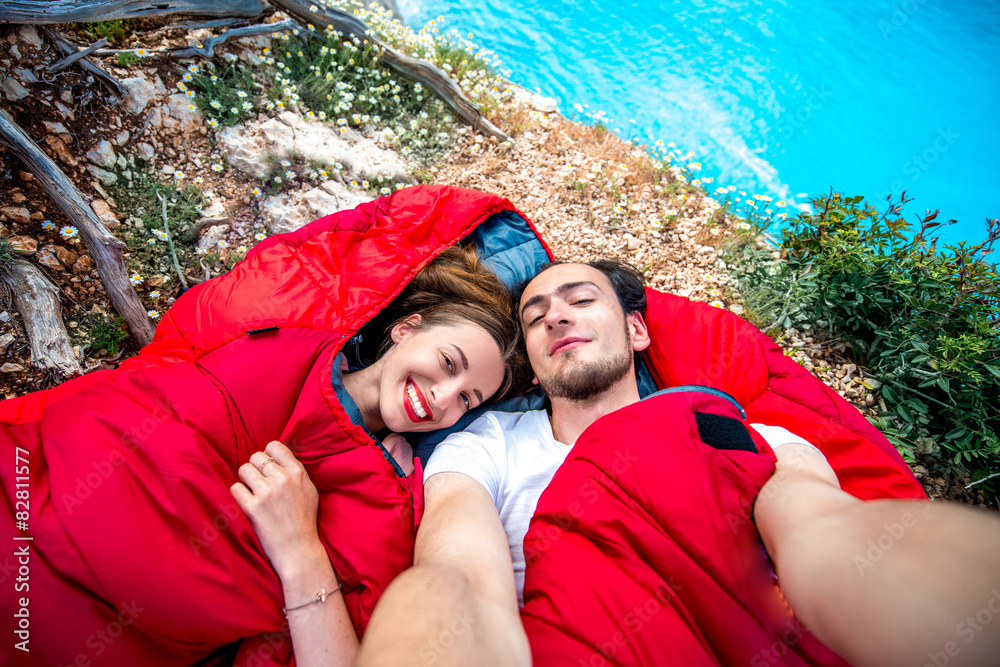 海边睡袋里的年轻夫妇