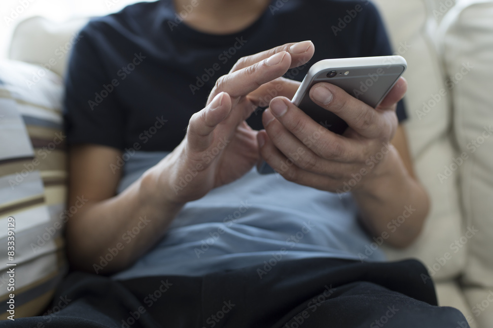 Men are using a mobile phone on the sofa