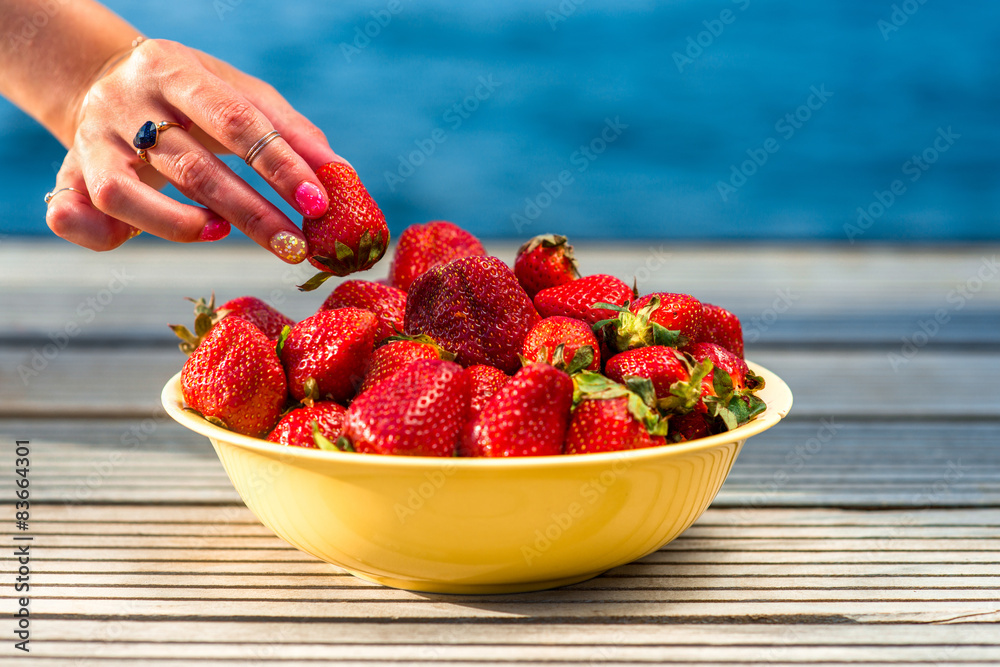从黄盘子里取出草莓