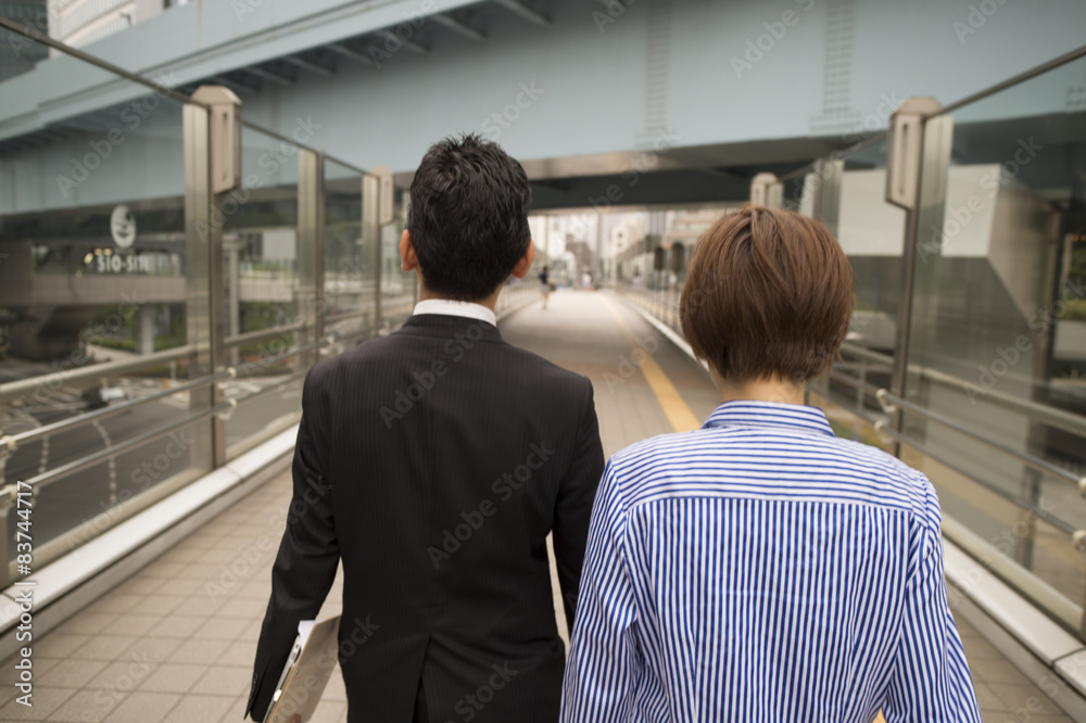 男人和女人走下人行天桥的后视图