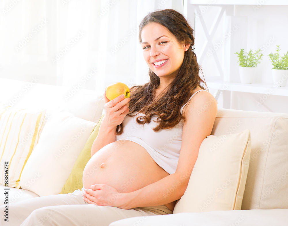 孕妇坐在沙发上吃苹果