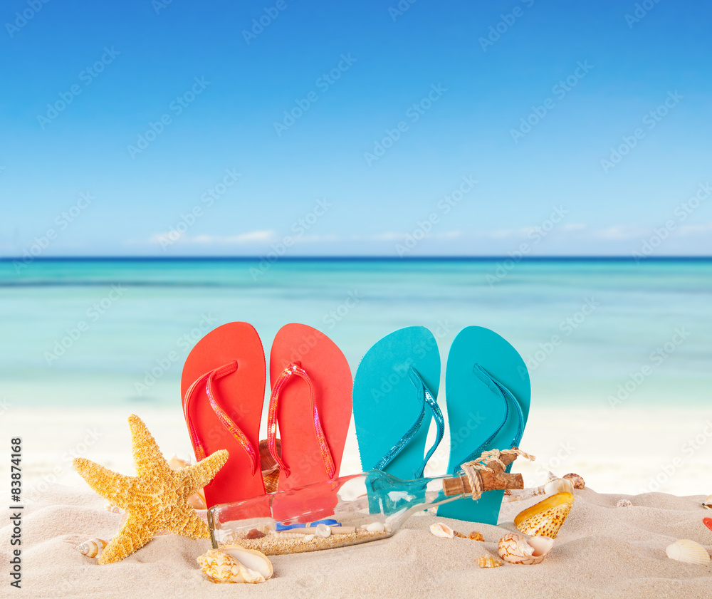 带红色凉鞋和贝壳的夏日海滩