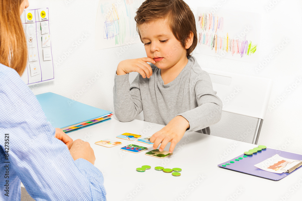 Preschooler boy and developing game with card