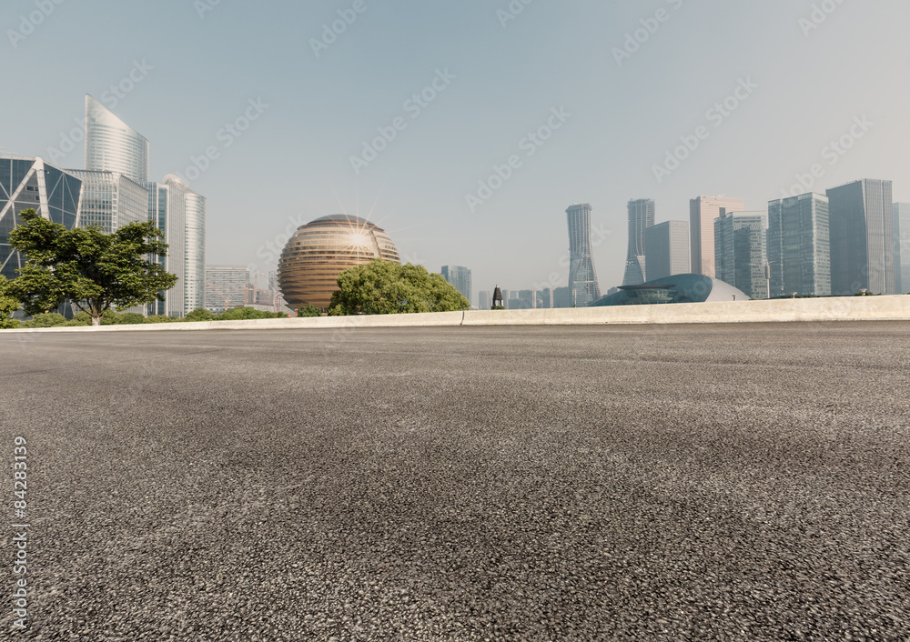 Asphalt road in front of the modern city， in hangzhou，china。