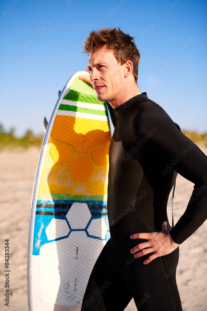 适合运动的年轻冲浪者和他的冲浪板