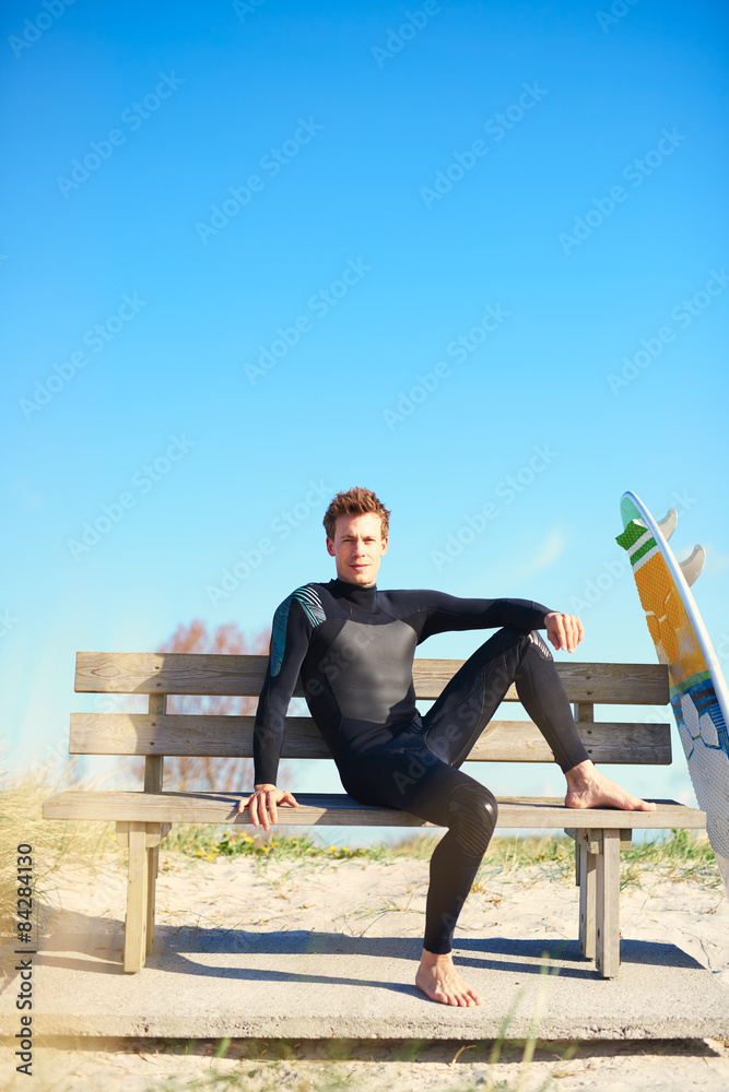放松的冲浪者在木长椅上等待