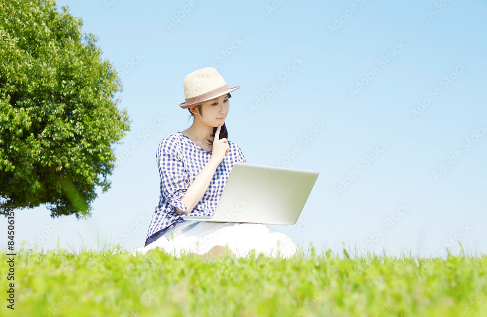 外でノートパソコンを使う女性