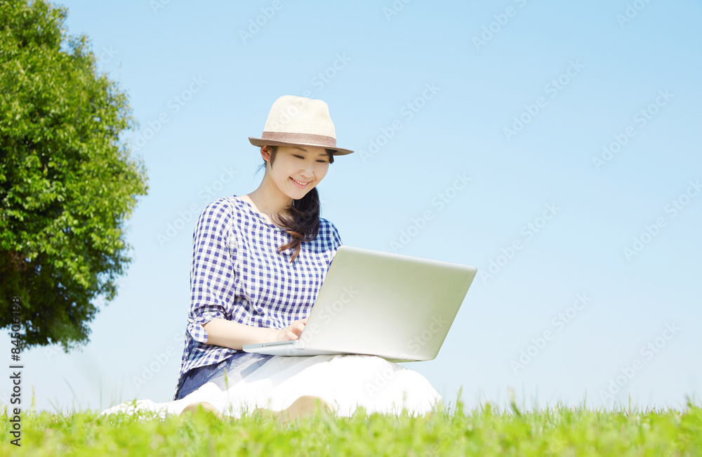 外でノートパソコンを使う女性