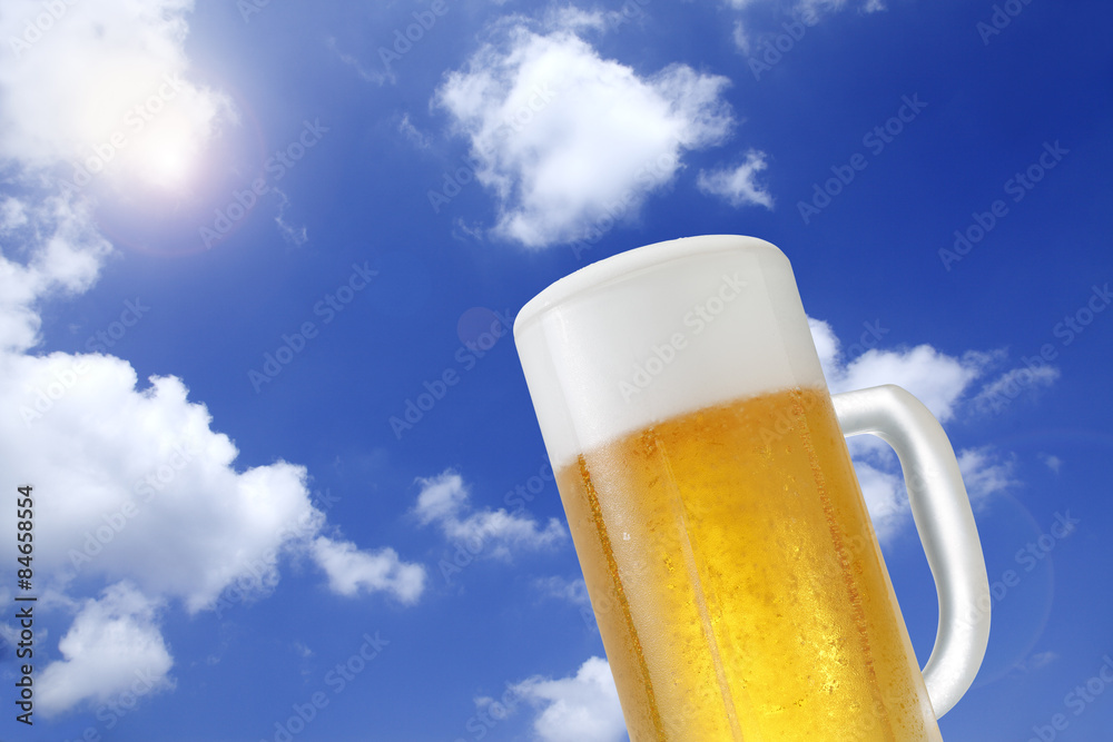 生ビール/真夏の青空に白い雲が浮かぶ背景にキンキンに冷えた生ビールを配置しています