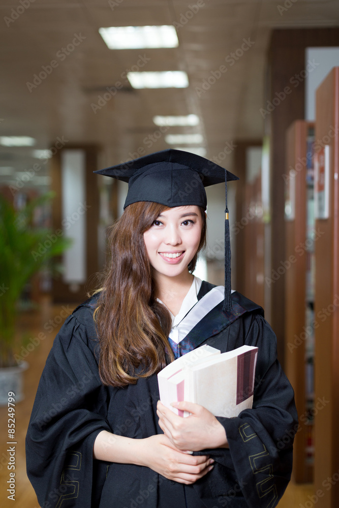 亚洲女学生拿着书，穿着学院装
