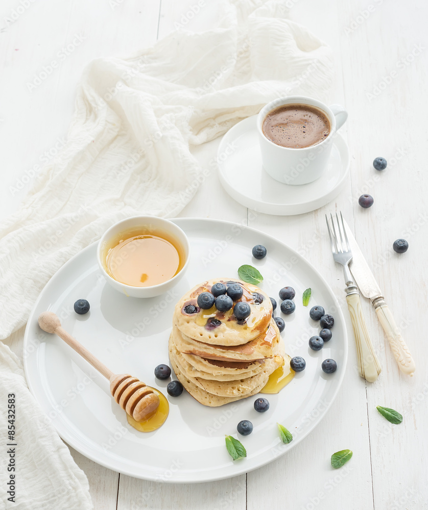 早餐套装。蓝莓煎饼配新鲜浆果和蜂蜜