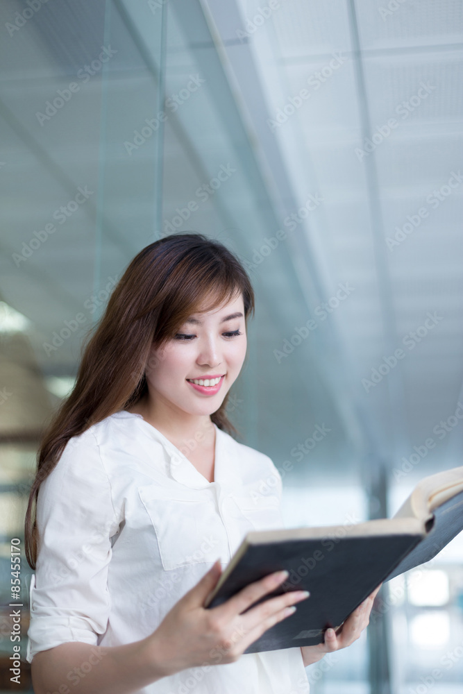 亚洲美女女学生在图书馆拿书