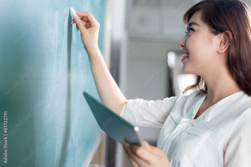 亚洲美女拿着平板电脑在黑板上写字