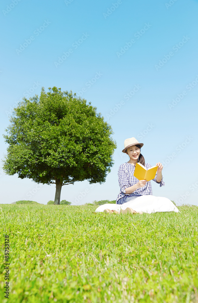 広場で本を読む女性