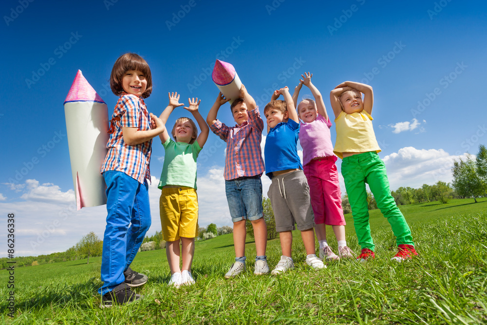 一群孩子站在纸火箭玩具旁边