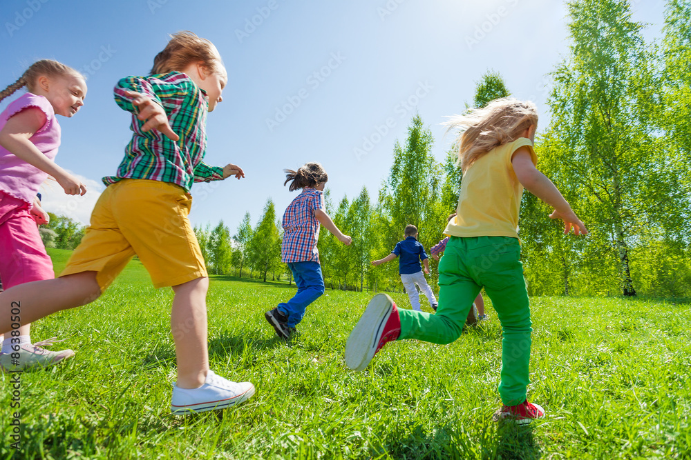 许多孩子一起在绿色公园里跑步