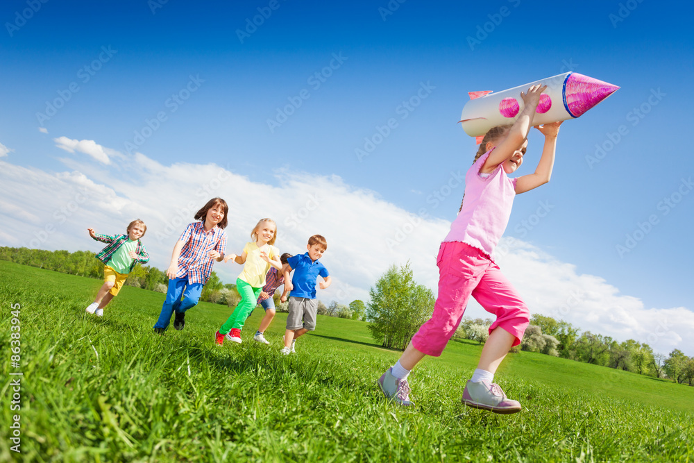 小女孩拿着火箭纸箱玩具和孩子们一起奔跑