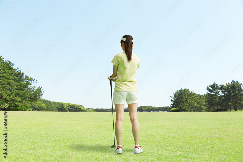 ゴルフ場に立つ女性　後ろ姿