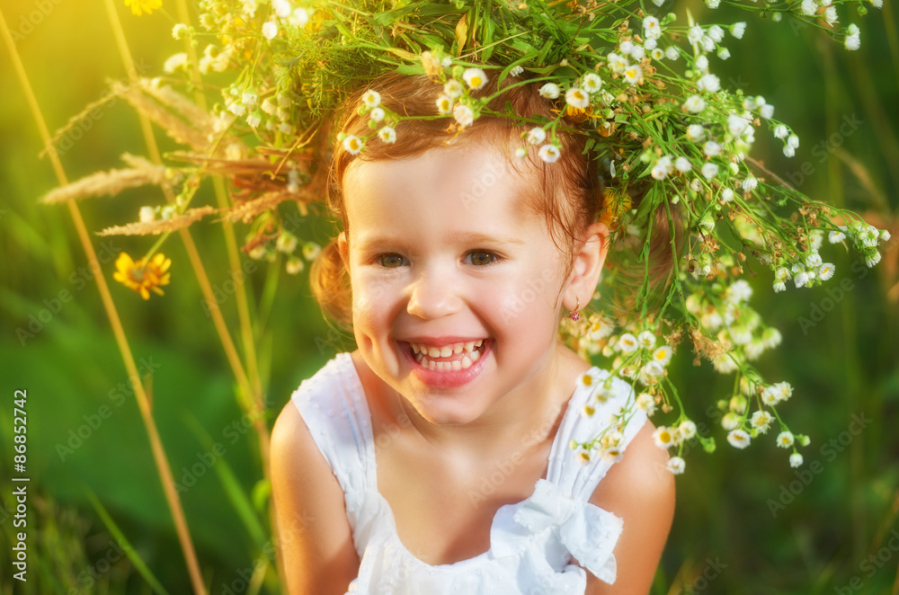 戴着花环的有趣快乐的女婴在大自然中开怀大笑