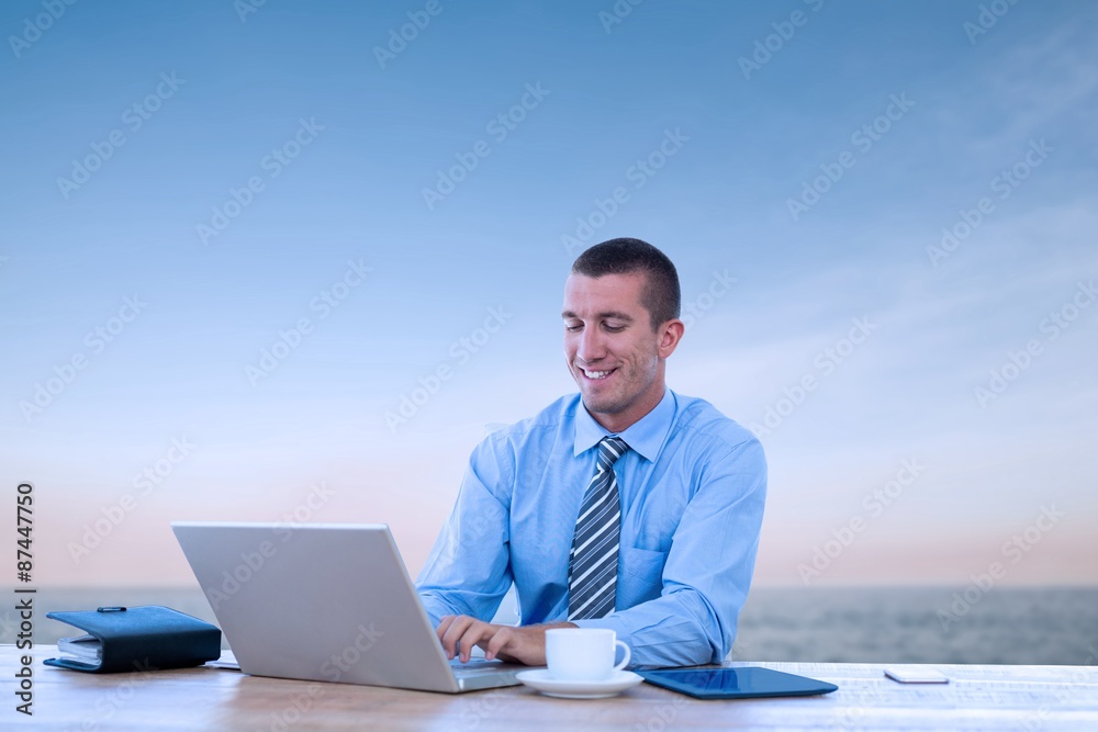 微笑的商人拿着笔记本电脑工作的合成图像